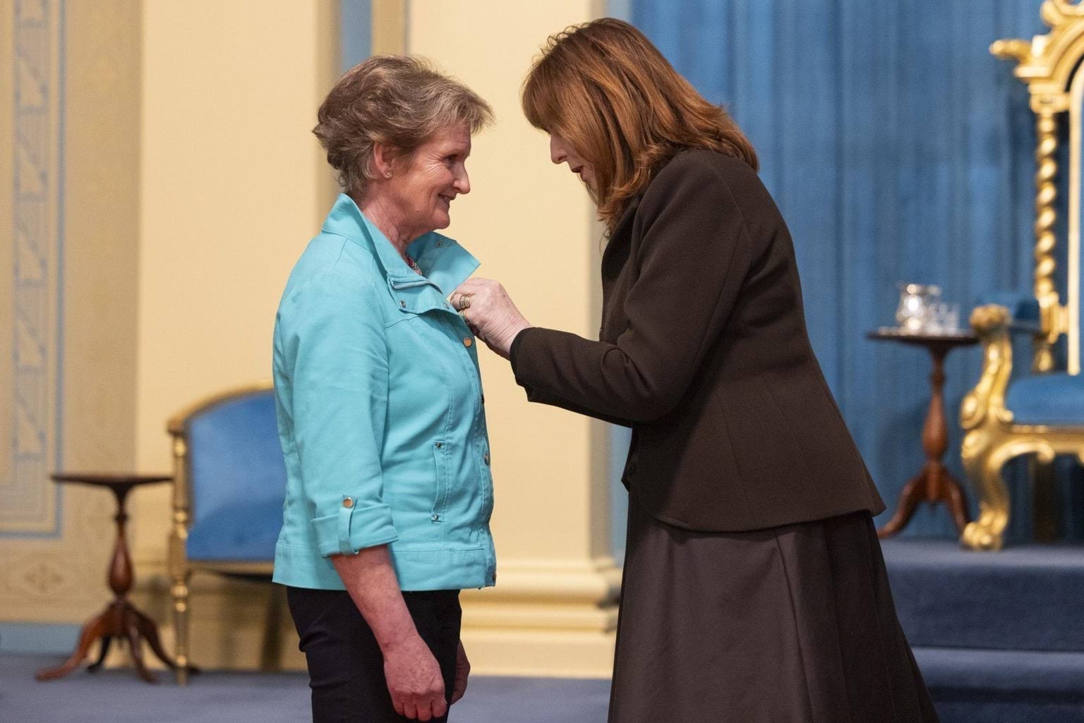 Governor presenting a recipient with their King's Birthday Honour.