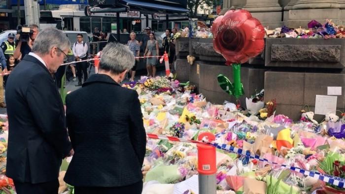 Her Excellency the Hon Linda Dessau AC and Mr Anthony Howard laying flowers at the Bourke Street tribute